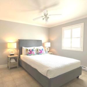 a bedroom with a bed with a ceiling fan at Lantern Hill & Hollow in Ingonish Beach