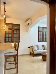 a kitchen and living room with a table and chairs at Nyumbani Stonetown in Zanzibar City