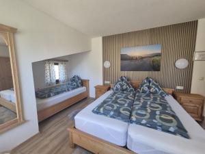 a bedroom with two beds and a mirror at Pyhrn Alps Inn "24h Self-Check-in-Hotel" in Spital am Pyhrn +13 photos