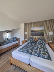 a bedroom with two beds with blue pillows at Pyhrn Alps Inn "24h Self-Check-in-Hotel" in Spital am Pyhrn