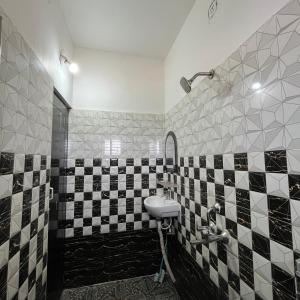 a bathroom with a black and white tiled wall at The Human Nest Coliving in Bhubaneshwar