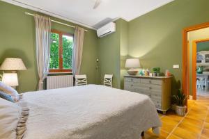 a bedroom with a bed and a dresser and a window at Pino Vallegrande in Procchio