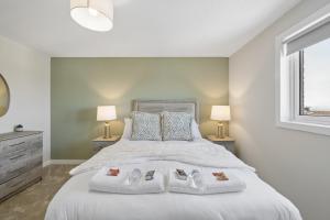 a bedroom with a large white bed with two lamps at Lime Grove House in Dalkeith