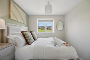 a bedroom with a white bed and a window at Lime Grove House in Dalkeith