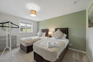 a bedroom with two beds and a window at Lime Grove House in Dalkeith