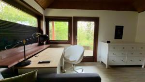 a room with a desk and a chair and windows at Kleine Auszeit Buchholz in Buchholz in der Nordheide