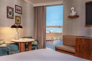 a hotel room with a bed and a table and a window at The Royal Sonesta Boston in Cambridge