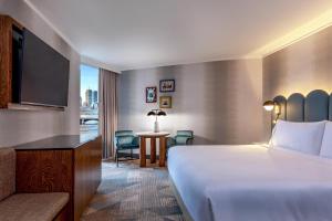 a hotel room with a bed and a desk and a television at The Royal Sonesta Boston in Cambridge