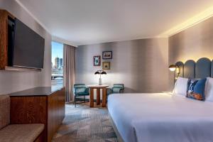 a hotel room with a bed and a desk and a television at The Royal Sonesta Boston in Cambridge