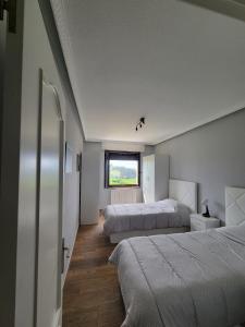 a bedroom with two beds and a window at CASA FREDO in Cóbreces +24 photos