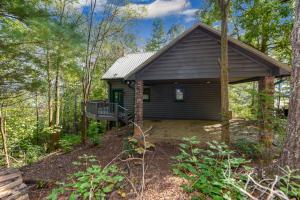 a small cabin in the woods with a porch at Tree Tops in Townsend