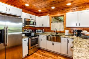 a kitchen with white cabinets and a stainless steel refrigerator at Tree Tops in Townsend