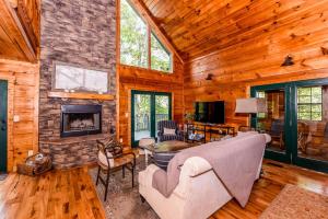a living room with a couch and a fireplace at Tree Tops in Townsend