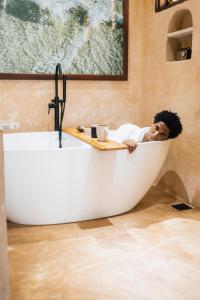 a man sitting in a bath tub in a bathroom at Nyumbani Stonetown in Zanzibar City +109 photos