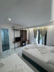 a bedroom with two beds and a large window at Prestige Hotel in Ksamil