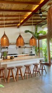 a kitchen with wooden stools and a counter with lights at Wild Wasi - Private Jungle Villa in Puyo