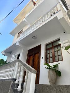 a white house with a staircase and a door at Nyumbani Stonetown in Zanzibar City