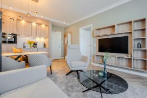 a living room with a table and chairs and a television at Yachthafen Barth - Ferienwohnung und Penthouses in Barth