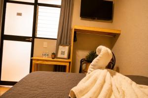 a person with their feet up on a bed with a towel at El Suburbio - Serapio Rendon in Morelia