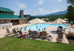 a group of people sitting around a pool at a resort at Hayloft in Townsend