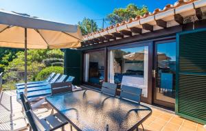 a patio with a table and chairs and an umbrella at Amaret in Deia