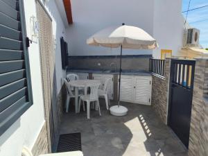 a patio with an umbrella and a table and chairs at O Refúgio in Mértola