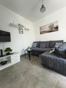 a living room with a couch and a flat screen tv at O Refúgio in Mértola