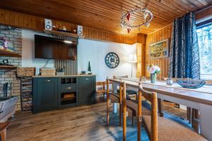 a dining room with a long table and chairs at Squirrel cottage Chata Veverica in Dolná Lehota