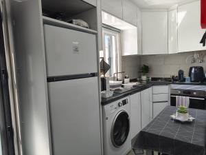 a kitchen with a white refrigerator and a washing machine at O Refúgio in Mértola
