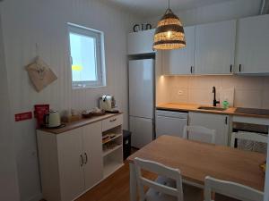 a kitchen with white cabinets and a table and a window at Casa D Alma in Aljustrel +16 photos