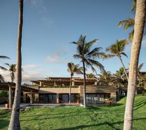 a house with palm trees in front of it at Aqua de Mar Condo Hotel in Icaraí