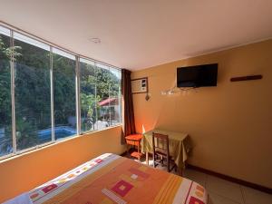 a bedroom with a bed and a table and a television at Cerro Verde in San Ramón