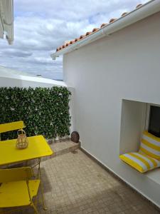 a yellow table and yellow chairs on a balcony at Casa D Alma in Aljustrel