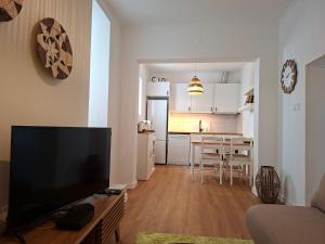 a living room with a flat screen tv and a kitchen at Casa D Alma in Aljustrel