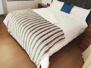 a bed with a black and white blanket on it at Askarium Cozy Haven in Nairobi