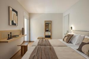 a white bedroom with a large bed and a chair at Annas's Main Street Apartment in Skala +7 photos