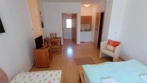 a living room with a bed and a kitchen at Pension Motel Anna in Lenora