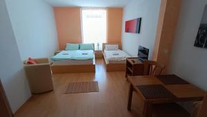 a small room with two beds and a table at Pension Motel Anna in Lenora