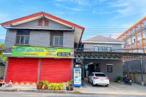a building with a red door on the side of a street at Tawee Green Boutique hotel in Phra Nakhon Si Ayutthaya