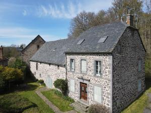 ein altes Steinhaus mit grauem Dach in der Unterkunft Celles - Demeure de la Tourille in Celles