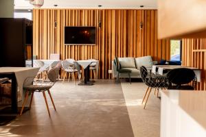 a living room with chairs and tables and a television at Vila Victor Mizuumi in Mamaia +46 photos