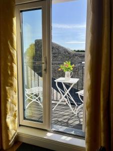 a sliding glass door leading to a balcony with a table at The Old Parish Office! in Midleton