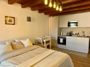 a bedroom with a bed and a table and a kitchen at casa duomo vicenza in Vicenza