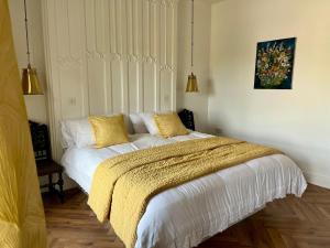 a bedroom with a bed with a yellow blanket on it at The Old Parish Office! in Midleton