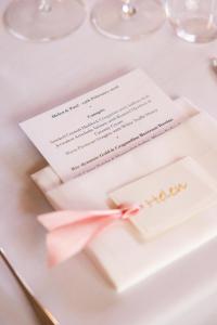 a wedding invitation on a table with a pink bow at Castle Lodge in Ludlow