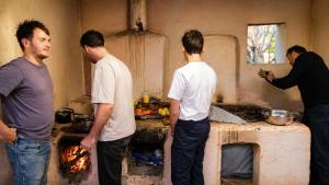 a group of men standing in a kitchen at Asraf village guesthouse in Aydar Kul’