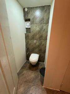 a small bathroom with a toilet in a room at TriboRoots Hostel in Anjuna
