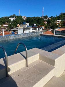 a swimming pool with a stairway leading to a building at Flat Gute Morro - Praça Central in Cairu