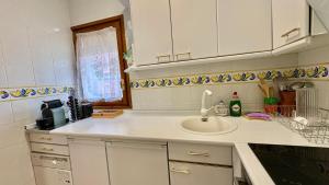 a white kitchen with a sink and a window at Jaca Centrum in Jaca +17 photos