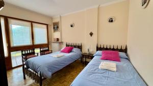 a bedroom with two beds with pink pillows at Jaca Centrum in Jaca